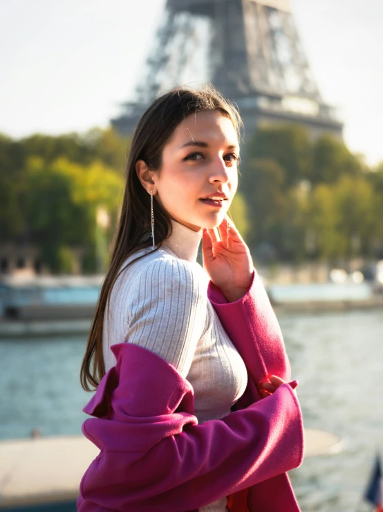 girl standing next to water with a tower in the background