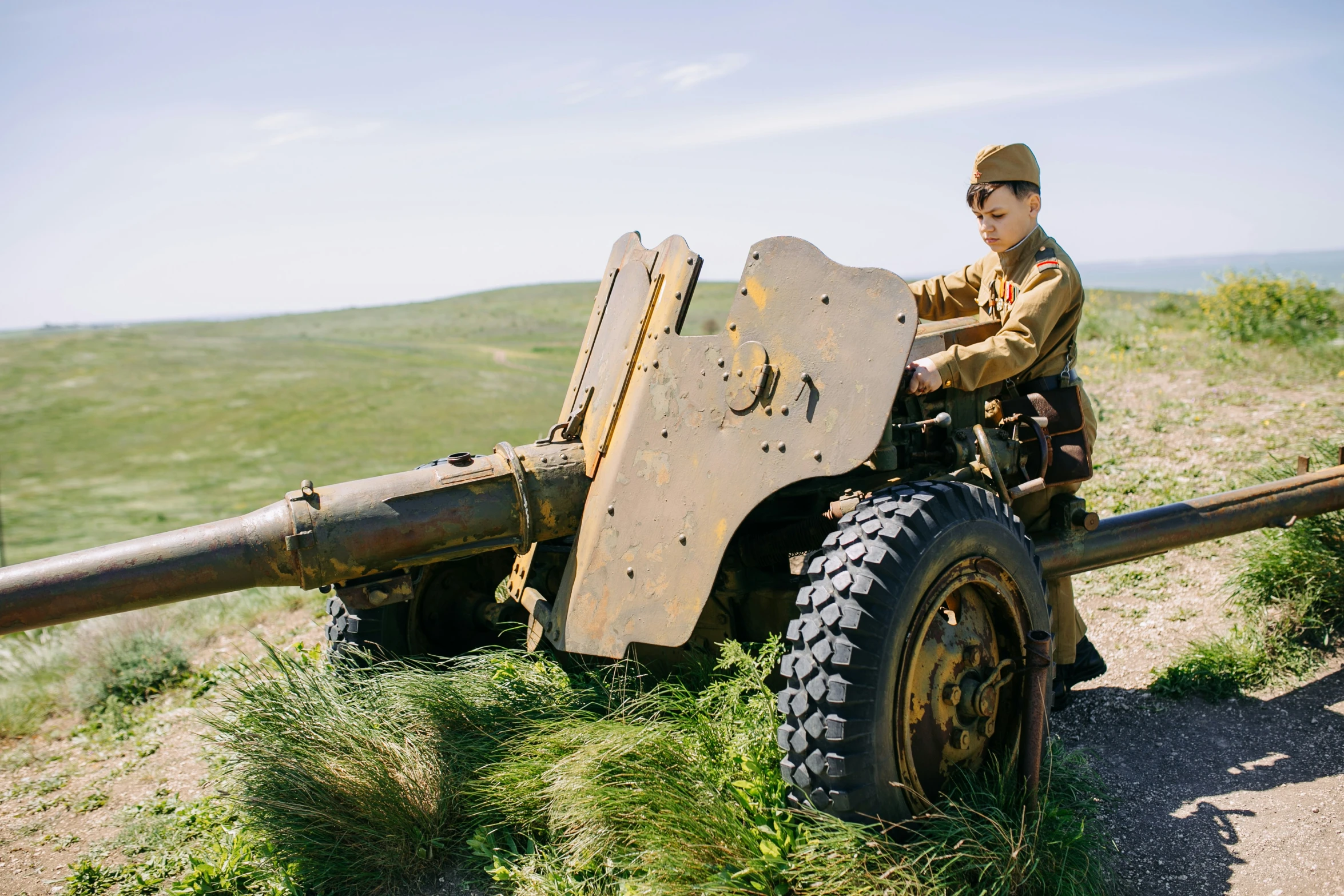 an officer stands next to a cannon on a hill