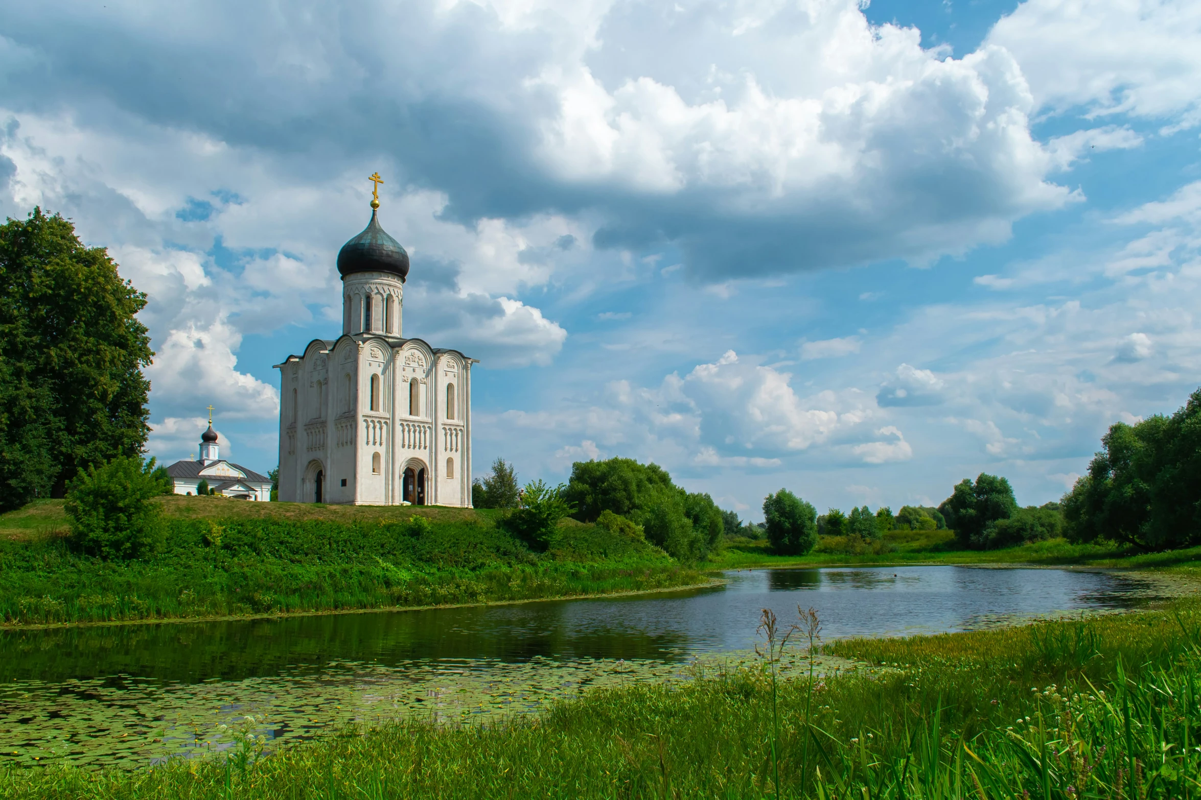 a large white church on the side of a river