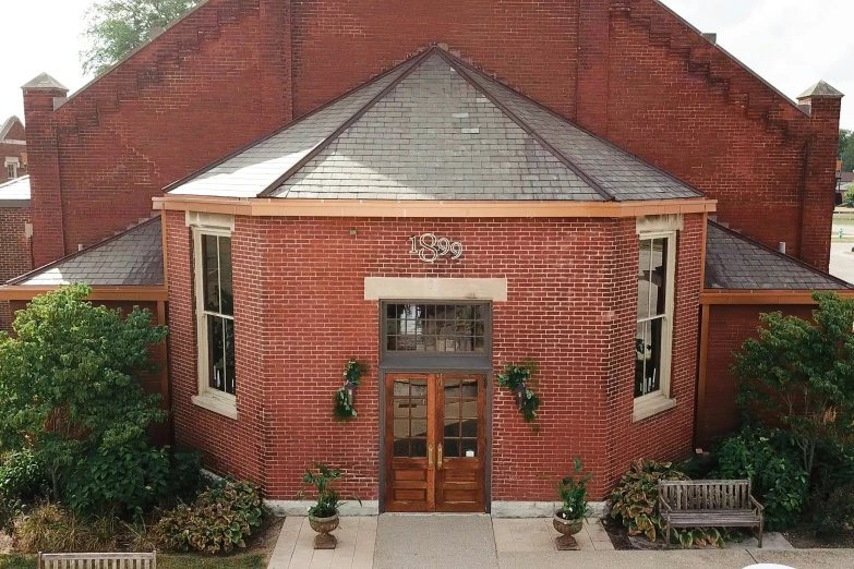 an outdoor red brick building with two benches around the outside area