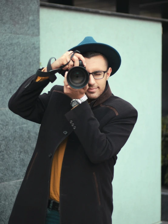 a man is standing near a building looking through a binoculars