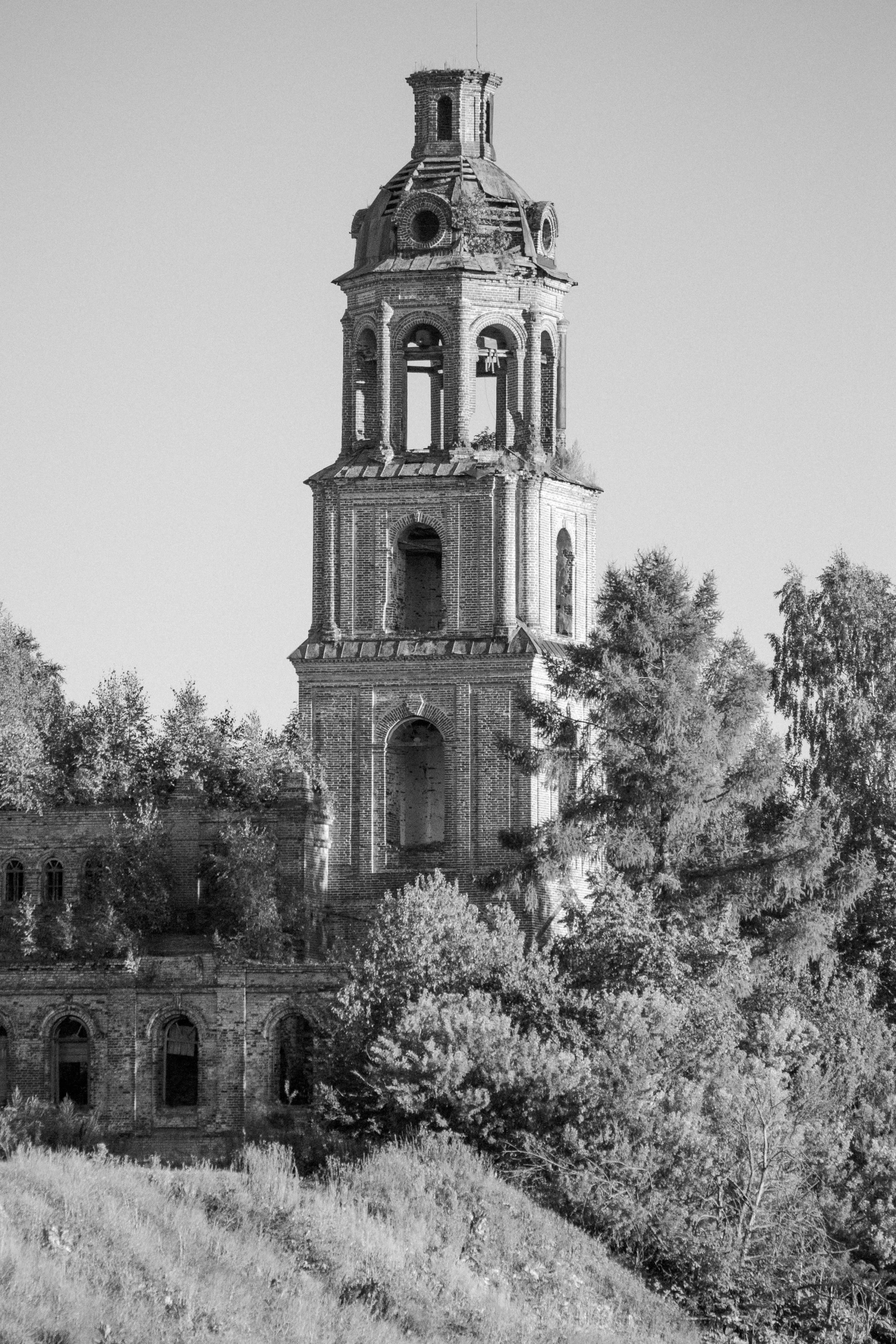 a black and white image of the tower of an old building with an angel above it