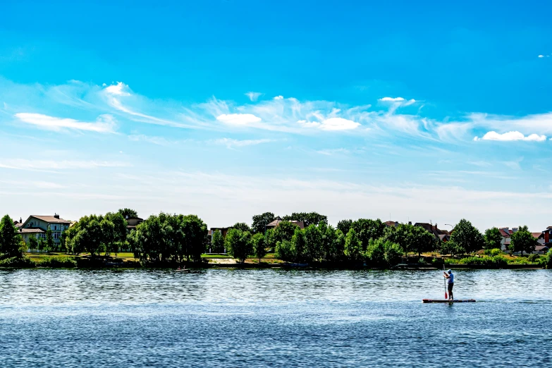 a lone person rowing a paddle boat on the lake