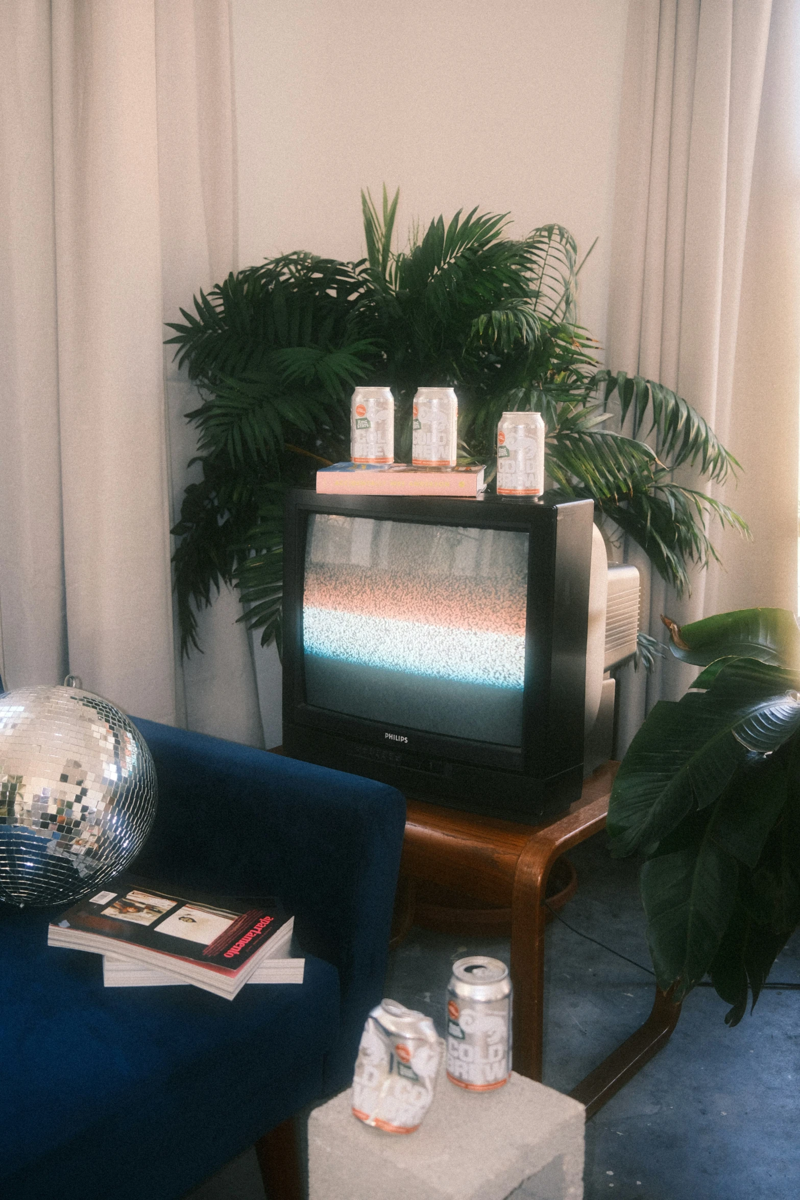 a living room with two tables and an old tv