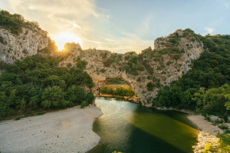 a bridge spanning across a river surrounded by cliffs