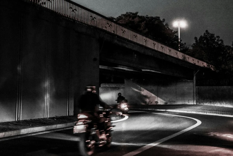 two bikers are passing underneath a street light