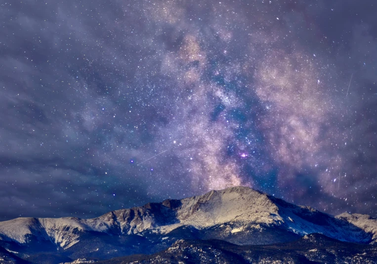 the night sky is filled with stars and milky above the mountains