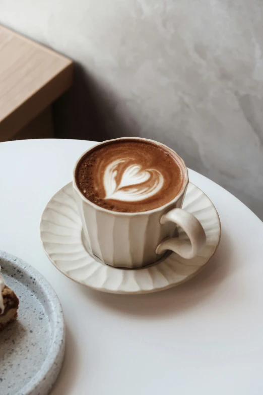 a table with a white plate and a cup with soing in it