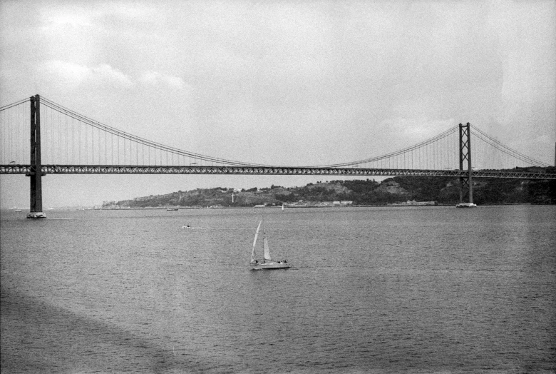 there is a boat floating in the water near the bridge