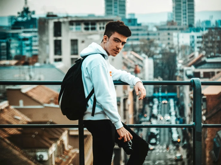 a man is standing on the edge of a building looking out onto the city