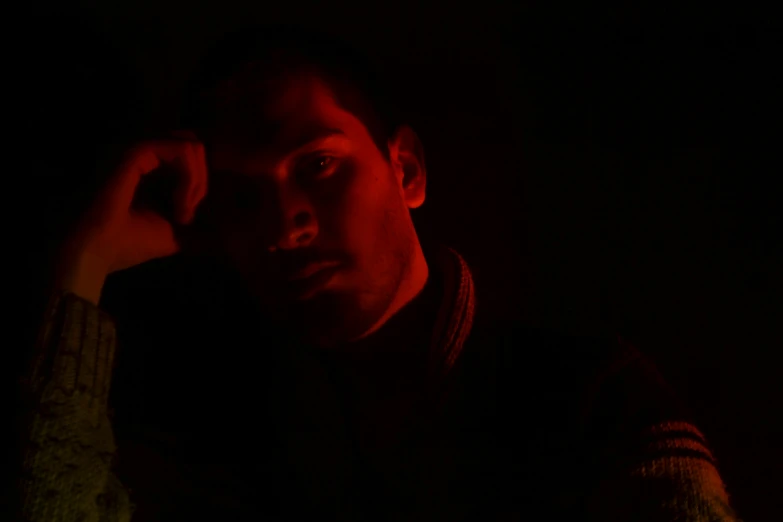 a man posing for a pograph in the dark