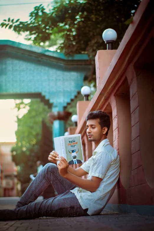 a man sitting on the ground reading a book