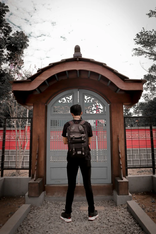 a man in black and grey looking at a door