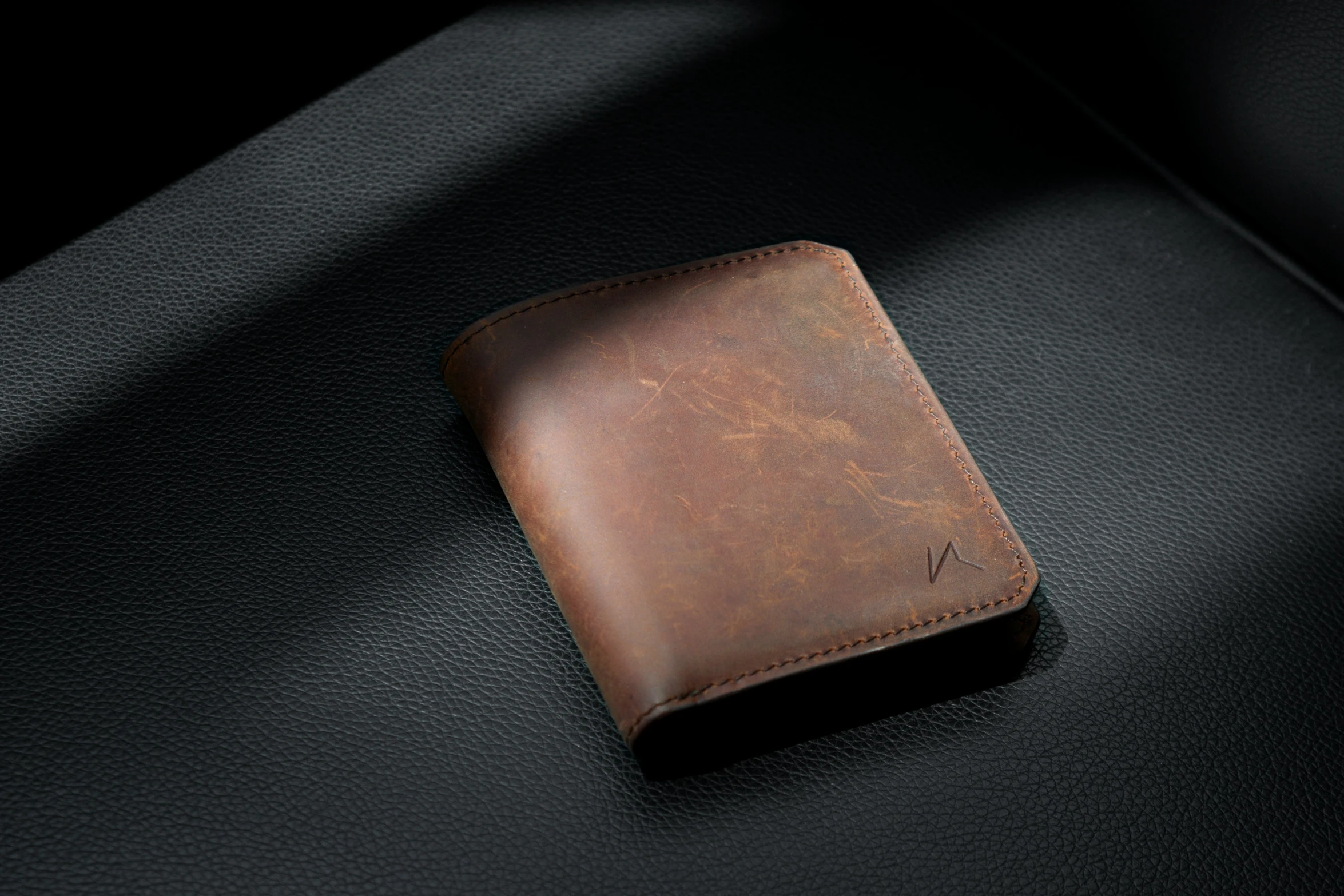 a piece of leather sitting on top of a black surface