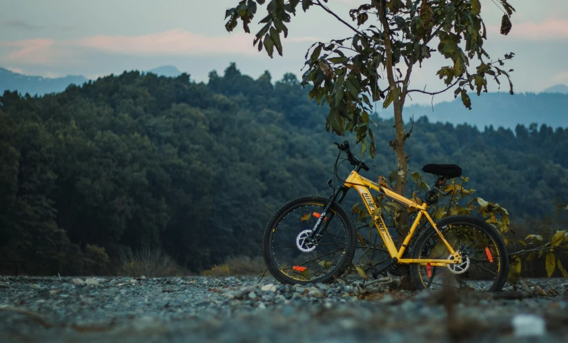 a yellow bicycle is parked in the sun