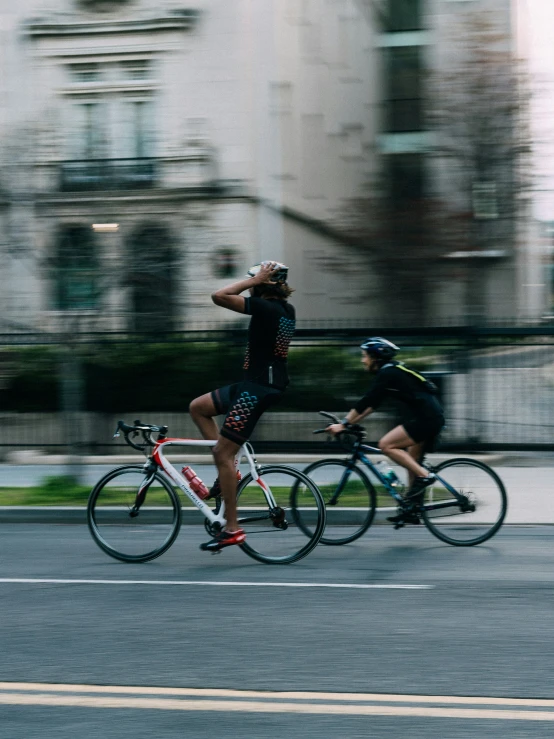 two people on bicycles riding next to each other