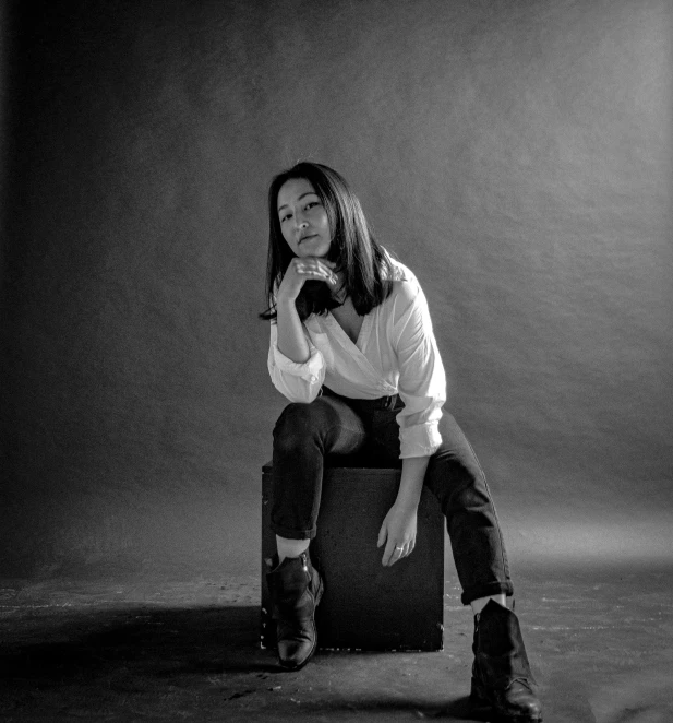 a black and white po of a person sitting on a chair