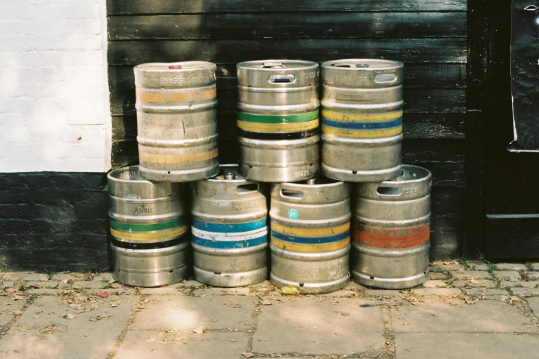 several kegs stacked up on brick sidewalk outside