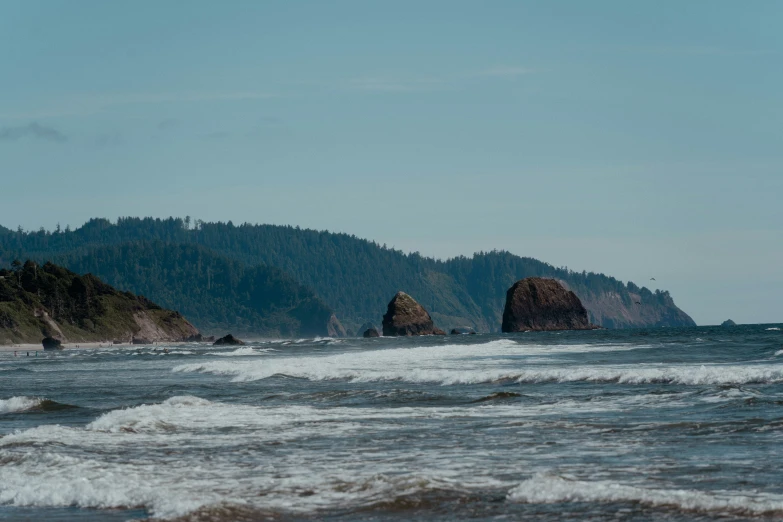 the waves on the ocean in front of a mountain