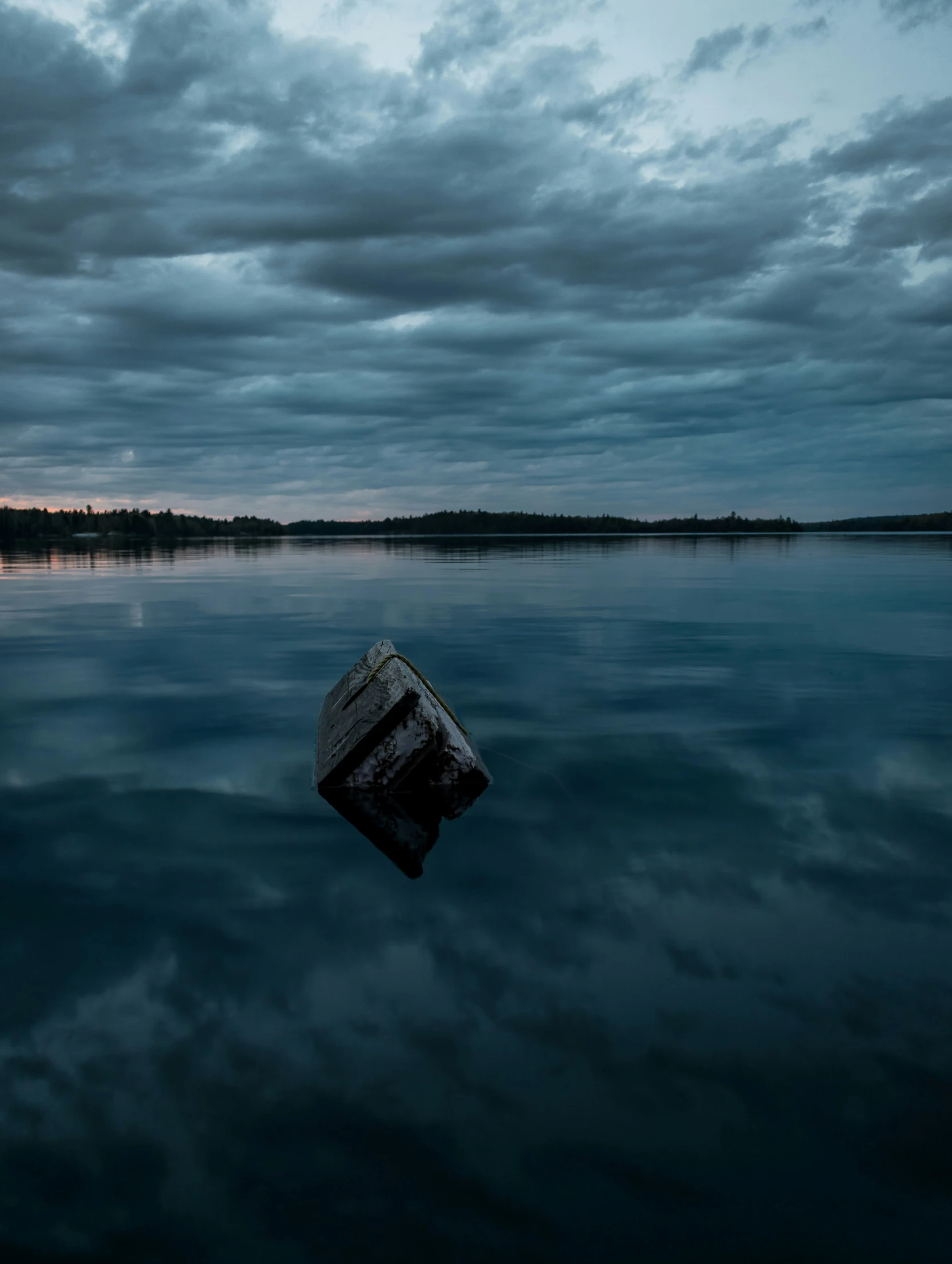 a small wooden boat is in the middle of the water