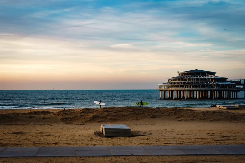 some benches are set out on the beach and people are playing in the ocean