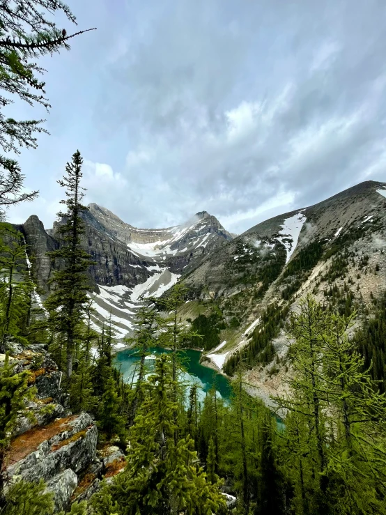 mountains and trees are around a small lake