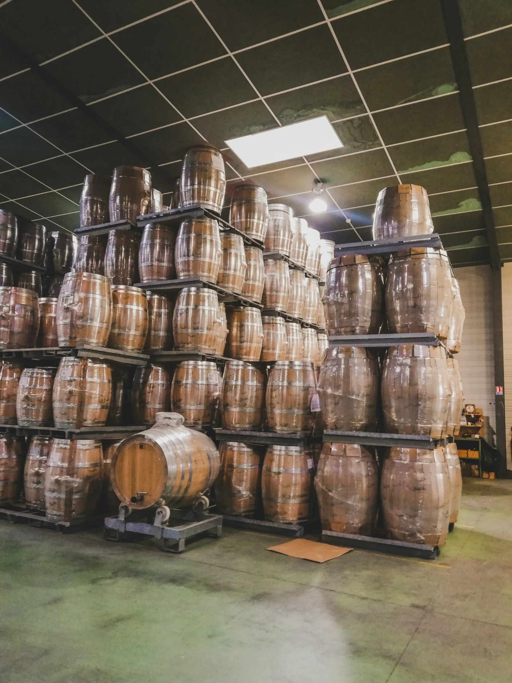 barrels stacked on wooden pallets in a warehouse