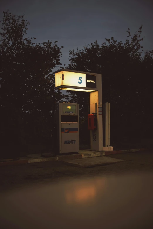 two gas pumps at an outdoor station lit up with lights