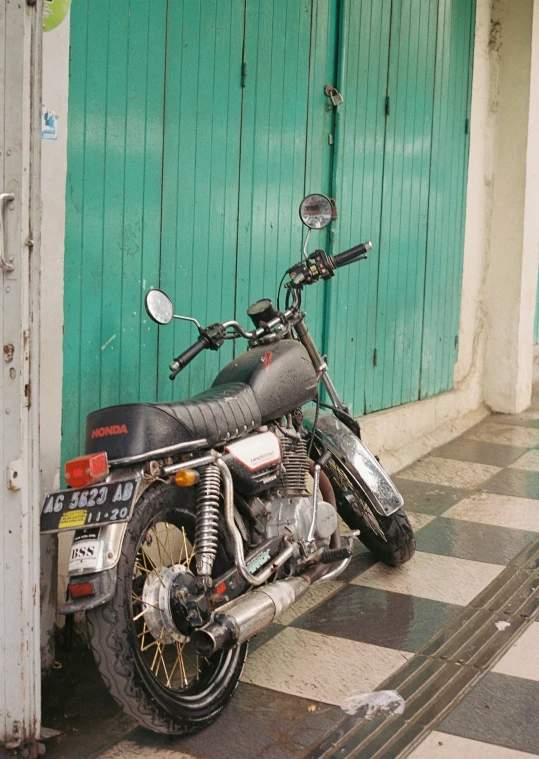 a motorcycle is parked near a blue wall