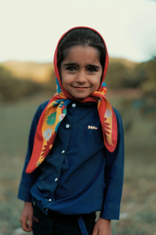 a child with dark hair and a red head scarf