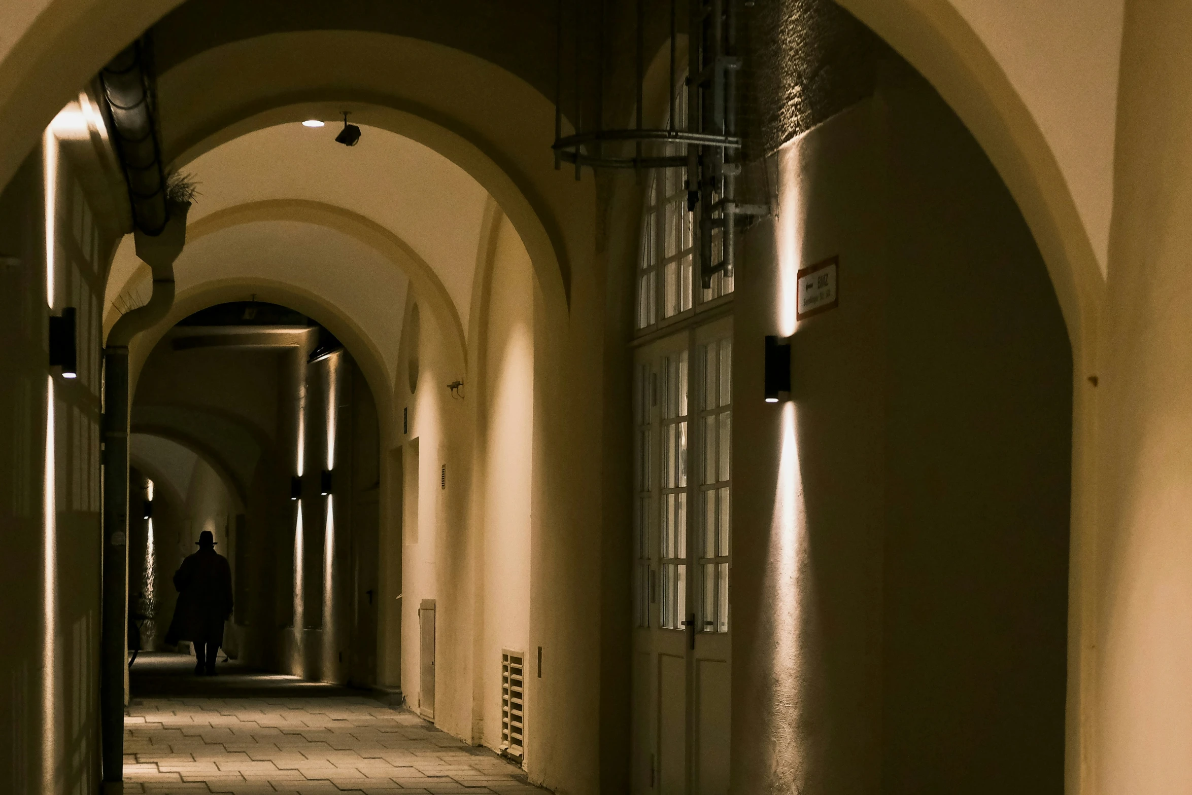 a hallway with arched ceilings and a tile walkway