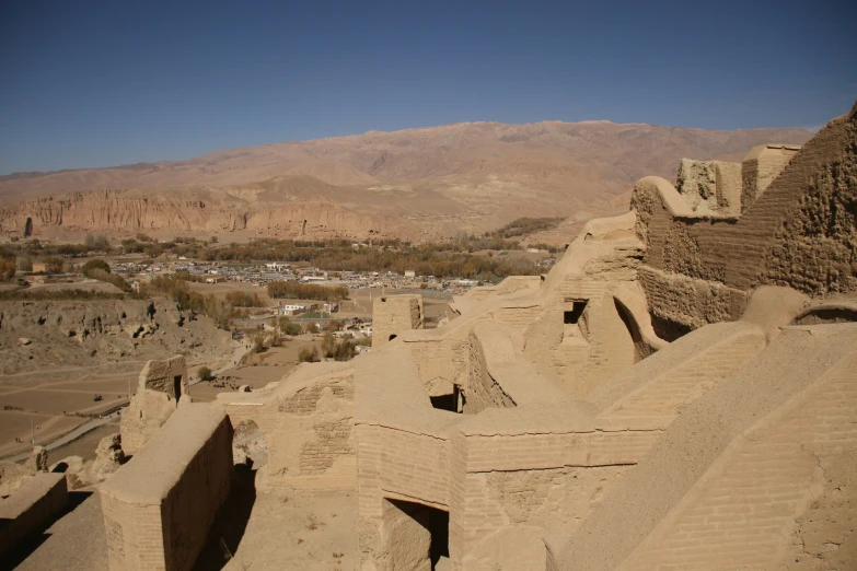 the ruins of adobe buildings with an overlook point on a mountain range