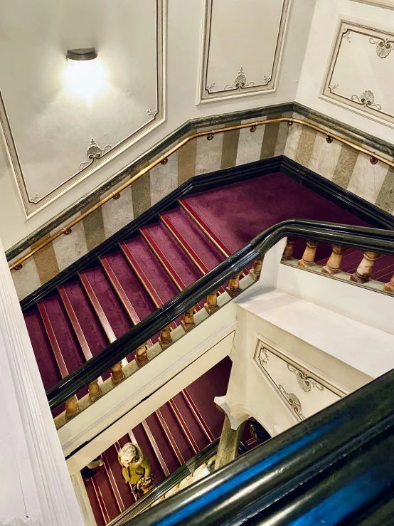 a tall staircase with maroon and white carpeting