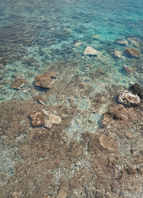 rocks in the water with blue water behind them