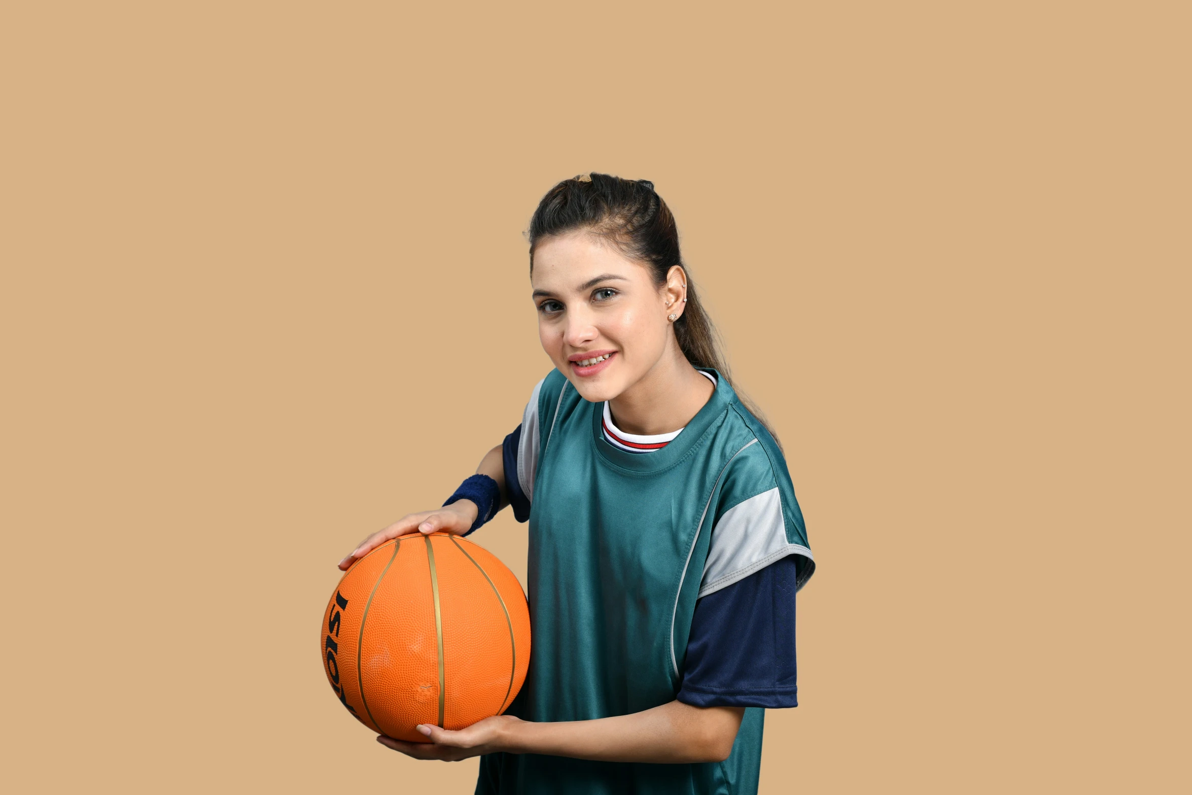 a woman holding an orange basketball in her hand