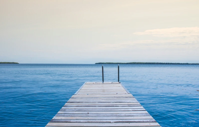 a pier next to an island with some water