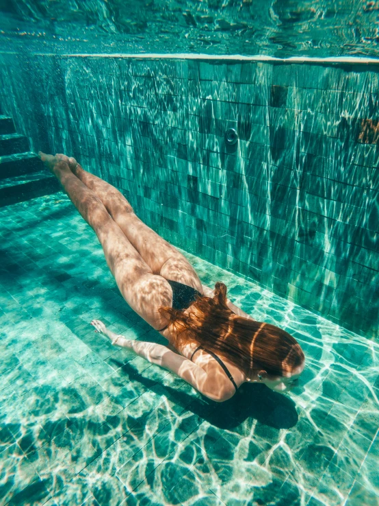 a woman swimming in clear blue water with a man snorering