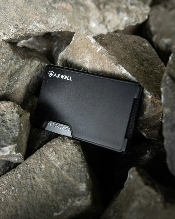 a wallet is shown laying on rocks next to rocks