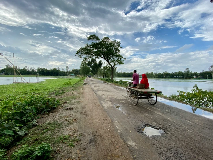 two women sitting on a bench next to the water