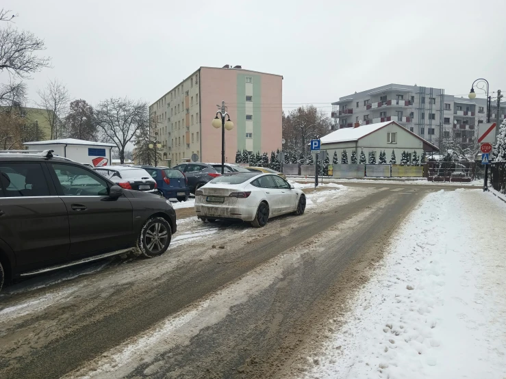 two cars are stopped on the side of the road on a snowy day