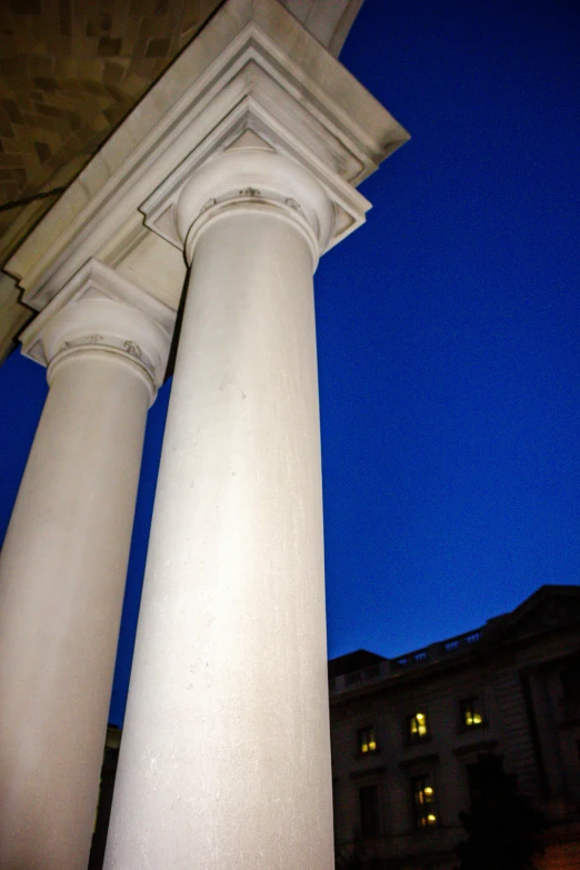 some white pillars and a building at night