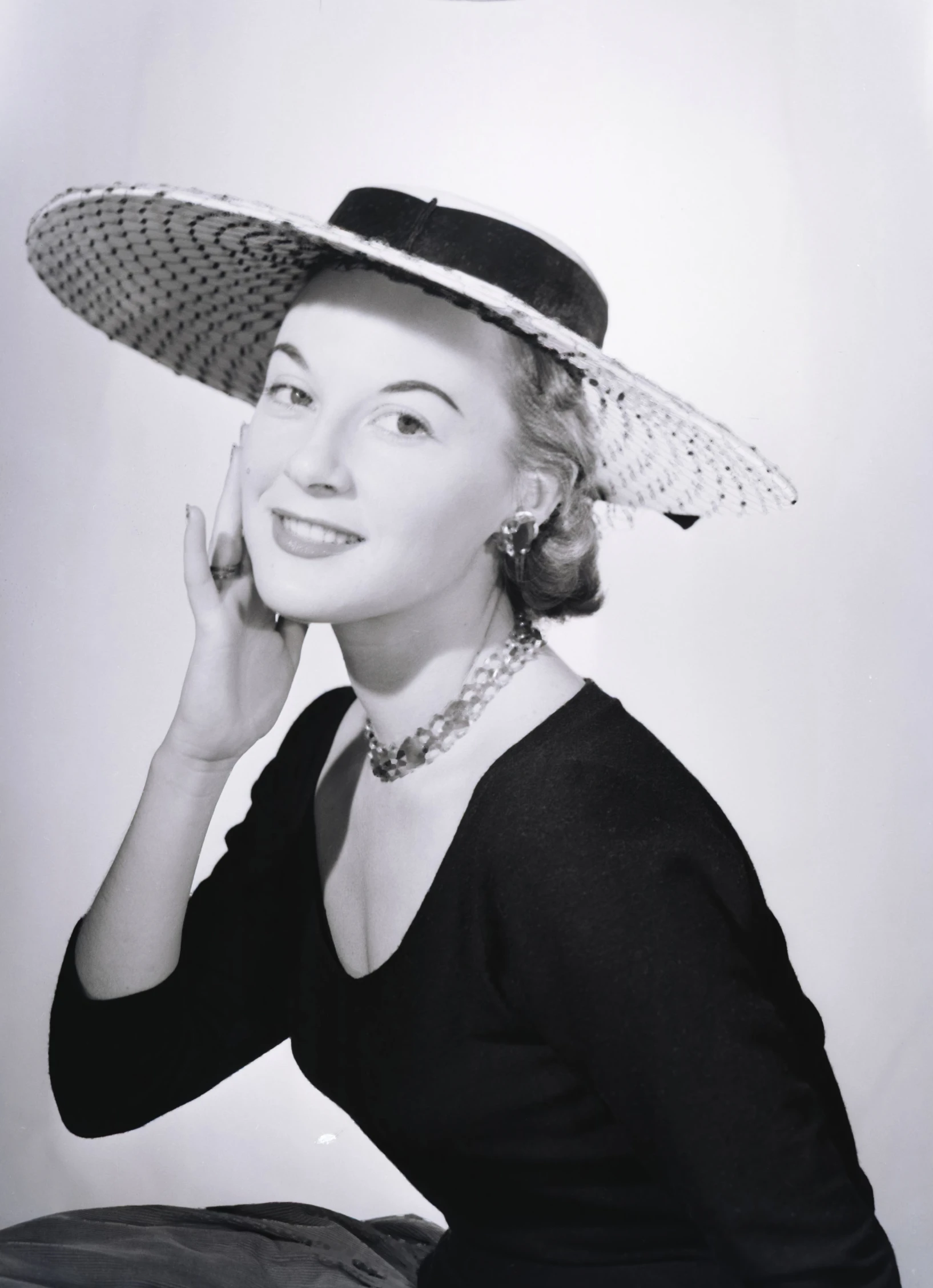 black and white pograph of woman wearing hat and dress