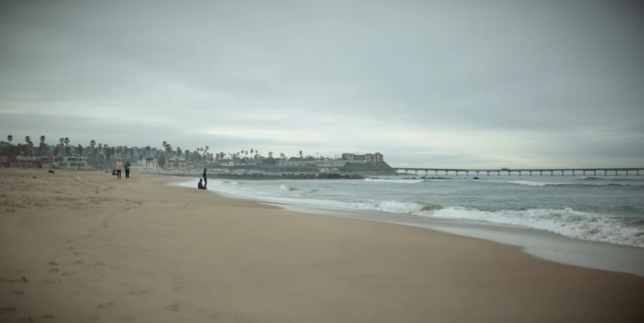 a very long beach with the shore covered in waves