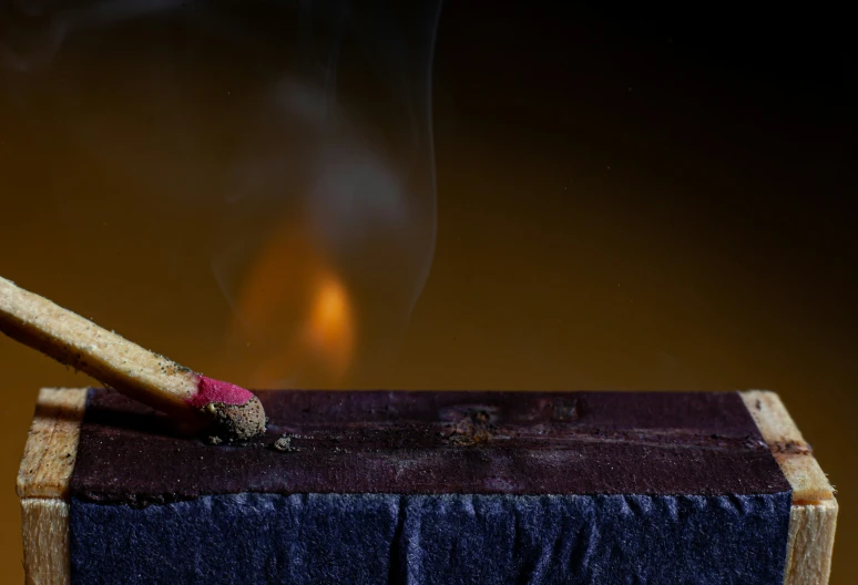 a candle with a flame on a table cloth