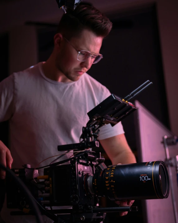 man holding up camera sitting on top of a tripod