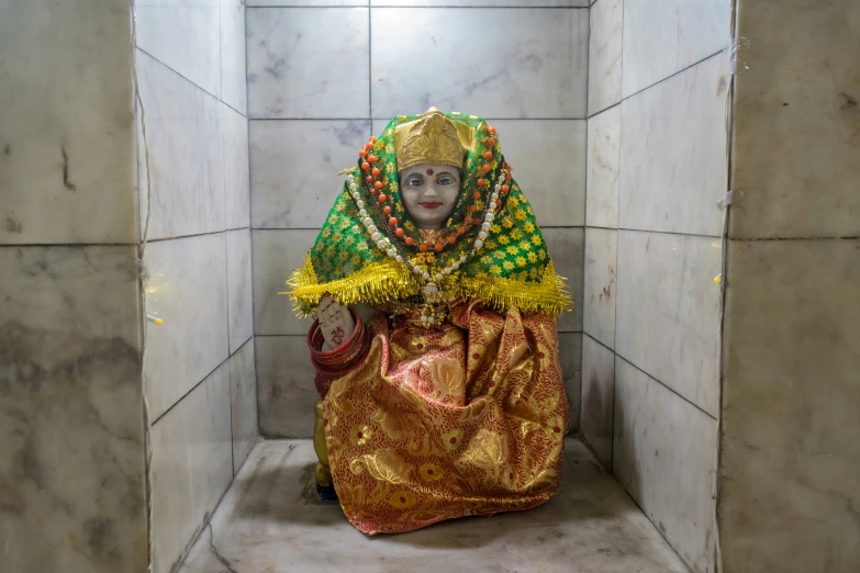 a woman sitting on the ground with an elaborate head dress and decorations on it