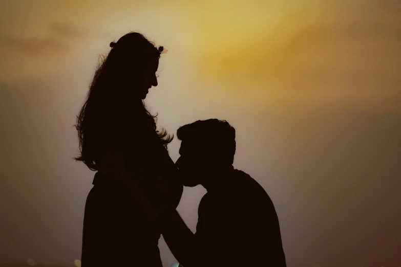 the couple is standing under a beautiful yellow sky