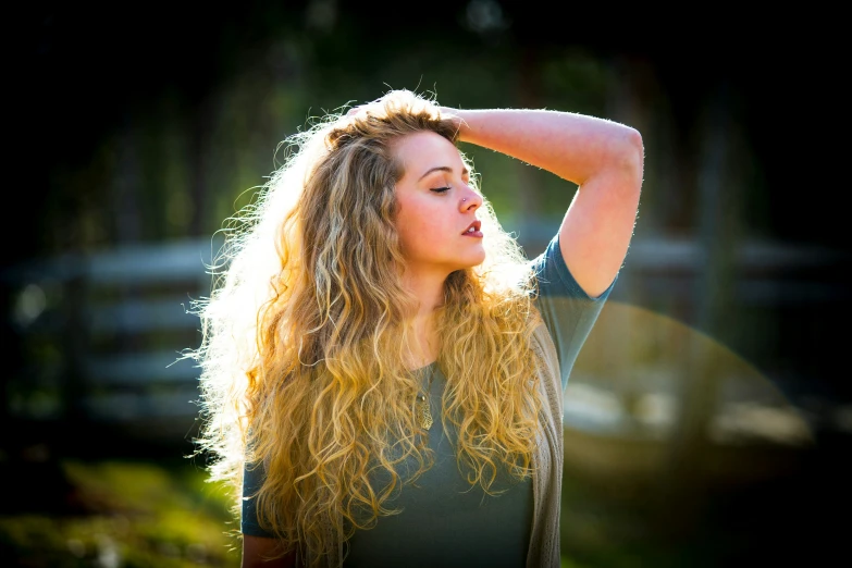 a girl with long hair and no face poses in the sun