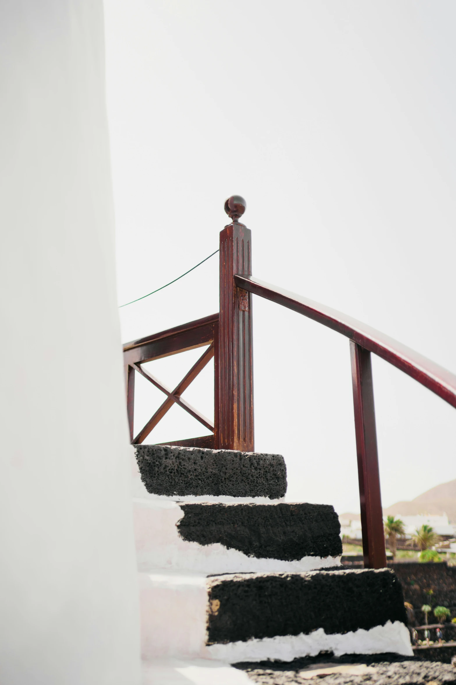 a stair rail leads down to a top of a building