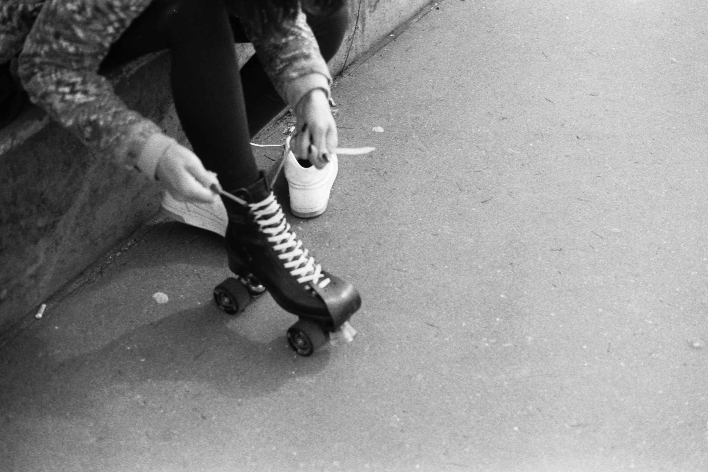 a person sitting on a wall with a skateboard